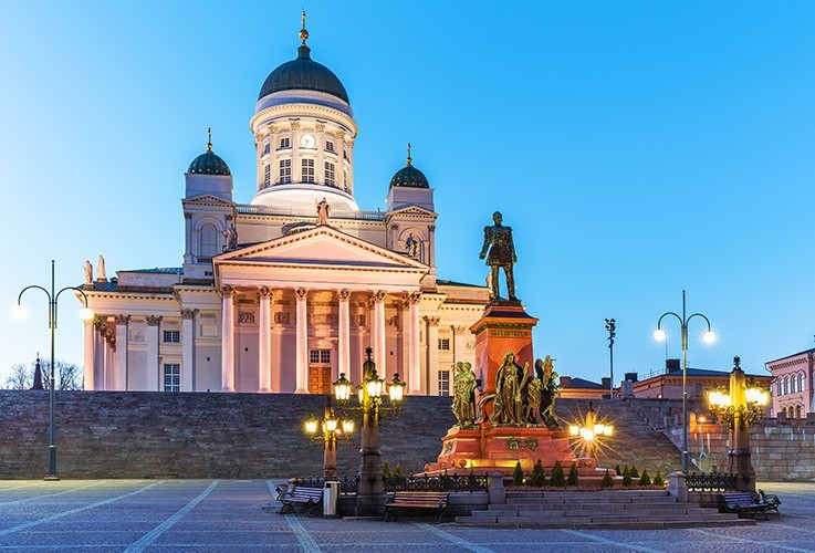 Large building with state in front at nighttime