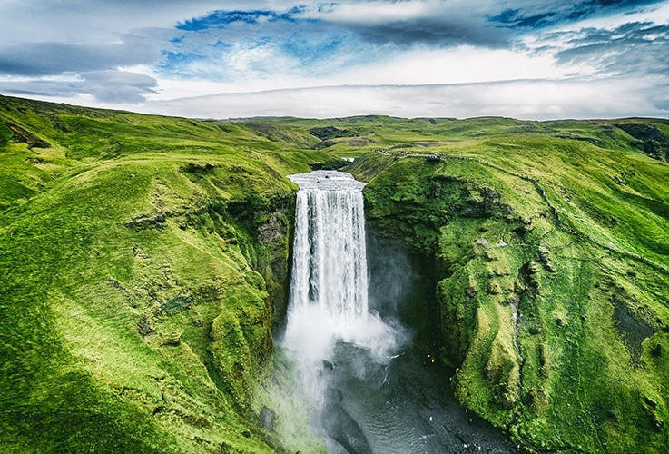 Waterfall surrounded by lush green hills