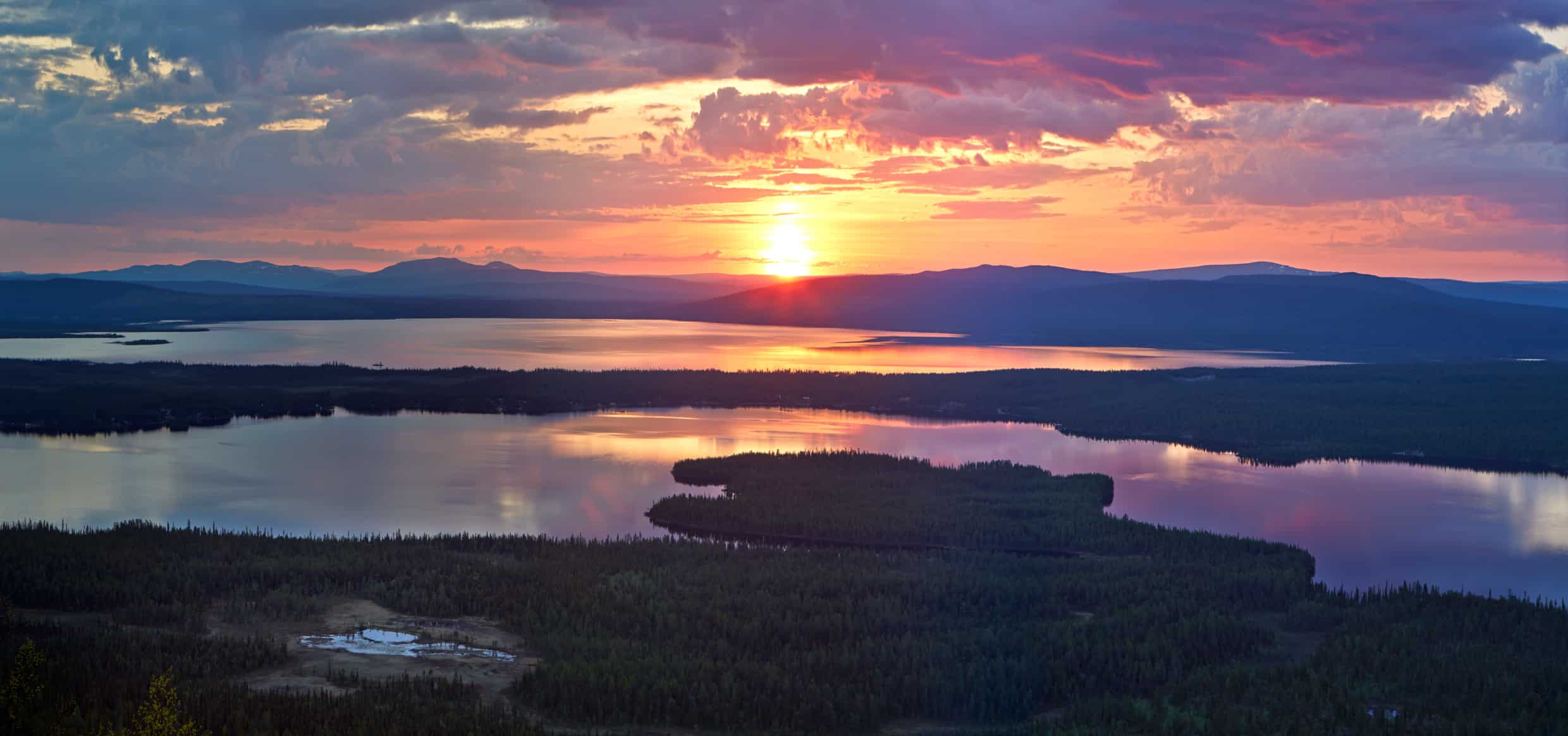 The Midnight Sun is a natural phenomenon occurring in summer months at latitudes north of the Arctic Circle where the sun remains visible at local midnight.